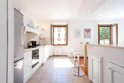 a kitchen with white cabinets and a counter at Elegantis San Giovanni Suite - Chic Apartment with Bathtub Near Historic Center, Metro & Tram Nearby in Rome