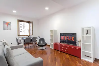 a living room with a couch and a tv at Elegantis San Giovanni Suite - Chic Apartment with Bathtub Near Historic Center, Metro & Tram Nearby in Rome