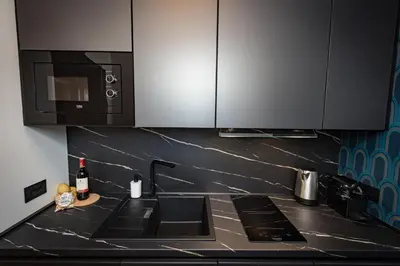 a kitchen with a counter top with a sink and a microwave at Puro Suite Frezza in Rome