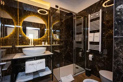 a bathroom with a sink and a shower at Puro Suite Frezza in Rome