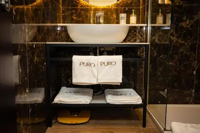 a bathroom with a sink and towels on a shelf at Puro Suite Frezza in Rome