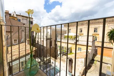 a balcony with a vase with flowers in it at Puro Suite Frezza in Rome