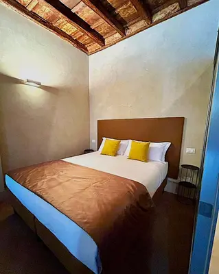 a bedroom with a large bed with yellow pillows at Pantheon in finestra in Rome