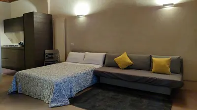 a bedroom with a bed and a couch with yellow pillows at Pantheon in finestra in Rome