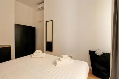 a bedroom with a bed with white sheets and a mirror at La Casa di Chantal in Rome