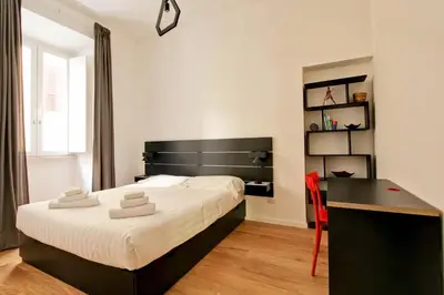 a bedroom with a bed and a desk and a table at La Casa di Chantal in Rome