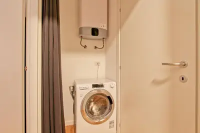 a washing machine in a bathroom next to a door at La Casa di Chantal in Rome