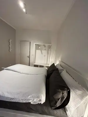 a bedroom with a bed with white sheets and a window at Cozy Donatello Apartment in Rome