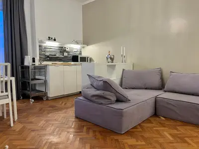 a living room with a couch and a kitchen at Cozy Donatello Apartment in Rome