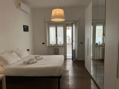 a bedroom with a white bed and a light at Le Crete Apartment in Rome