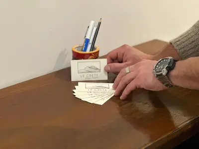 a person is putting a piece of paper on a table at Le Crete Apartment in Rome