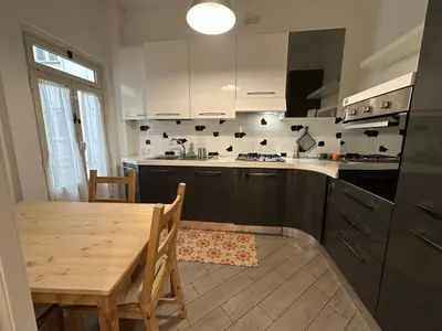 a kitchen with a wooden table and a dining room at Le Crete Apartment in Rome