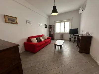 a living room with a red couch and a table at Le Crete Apartment in Rome