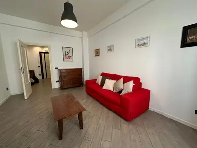 a living room with a red couch and a table at Le Crete Apartment in Rome