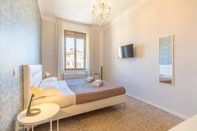 a bedroom with a bed and a table and a window at B&B Floret Roma San Giovanni in Rome