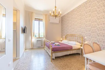 a small bedroom with a bed and a chandelier at B&B Floret Roma San Giovanni in Rome