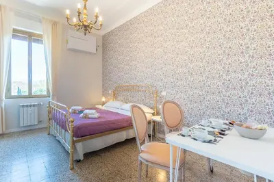 a bedroom with a bed and a table and chairs at B&B Floret Roma San Giovanni in Rome
