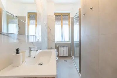a white bathroom with a sink and a shower at B&B Floret Roma San Giovanni in Rome
