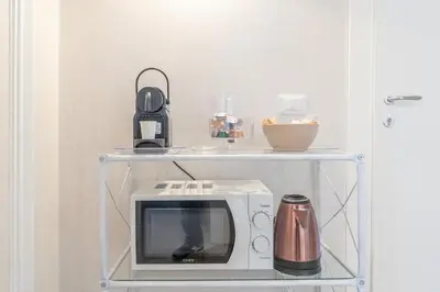 a microwave on a shelf with a coffee pot on it at B&B Floret Roma San Giovanni in Rome