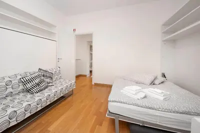 a white bedroom with two beds and a wooden floor at Irpini in Rome