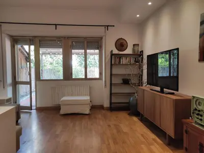 a living room with a flat screen tv and a wooden floor at La Terrazza del Poeta in Rome