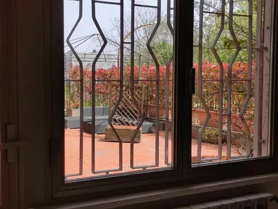 a window with a chair sitting on a patio at La Terrazza del Poeta in Rome