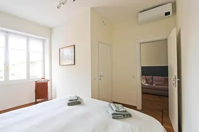 a bedroom with a bed with two remotes on it at Casa Luminosa in Monteverde in Rome