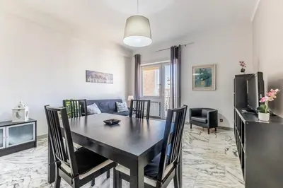 a dining room with a table and a couch at Iris Suite Colli Portuensi in Rome