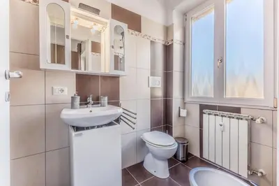 a bathroom with a sink and a toilet and a window at Iris Suite Colli Portuensi in Rome