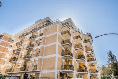 a tall brick building with balconies on it at Iris Suite Colli Portuensi in Rome