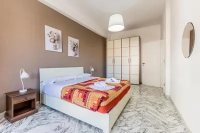 a bedroom with a king sized bed and a table at Iris Suite Colli Portuensi in Rome