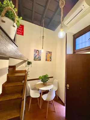 a dining room with a table and chairs and stairs at Trastevere Loft garden in Rome