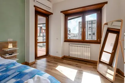 a bedroom with a bed and two windows at San Giovanni Al Colosseo in Rome
