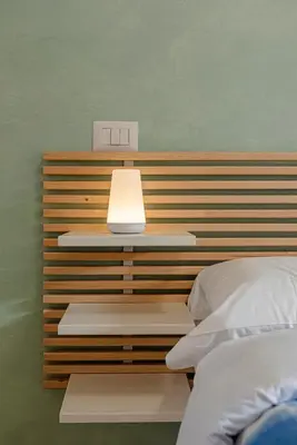 a bed with a light on top of a headboard at San Giovanni Al Colosseo in Rome