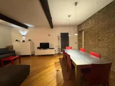 a living room with a table and a brick wall at New! Renovated Apt in Ancient Rome in Rome