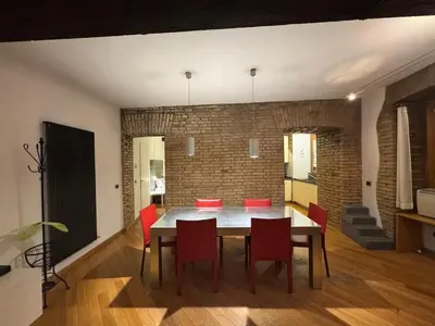 a dining room with a table and red chairs at New! Renovated Apt in Ancient Rome in Rome
