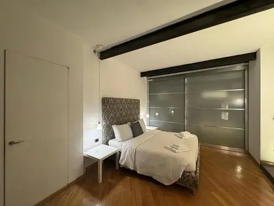a bedroom with a bed with a chair and a window at New! Renovated Apt in Ancient Rome in Rome