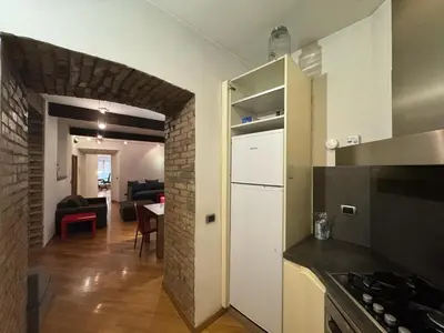 a kitchen with a white refrigerator and a living room at New! Renovated Apt in Ancient Rome in Rome