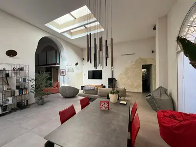 a large living room with a table and red chairs at loft Trastevere in Rome