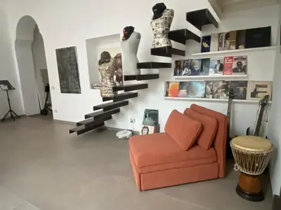 a living room with a orange chair and a staircase at loft Trastevere in Rome