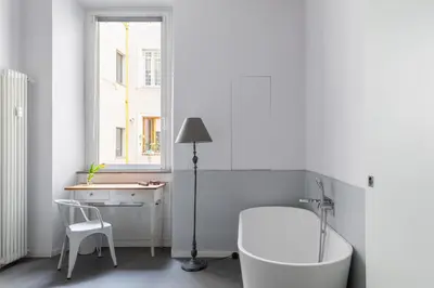 a bathroom with a tub and a table and a chair at Trastevere Modern 4BR 4baths, WIFI, AC, custom kitchen, living room in Rome