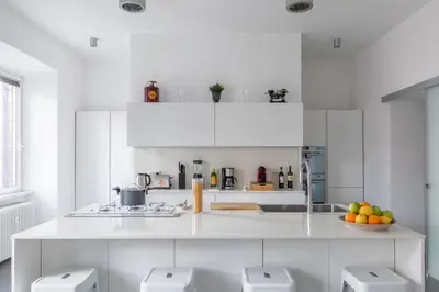 a white kitchen with a counter with fruit on it at Trastevere Modern 4BR 4baths, WIFI, AC, custom kitchen, living room in Rome