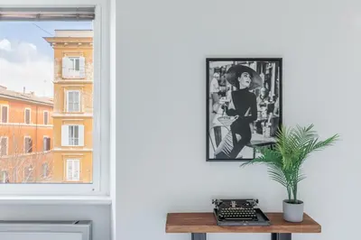 a picture on a wall next to a table with a plant at Trastevere Modern 4BR 4baths, WIFI, AC, custom kitchen, living room in Rome