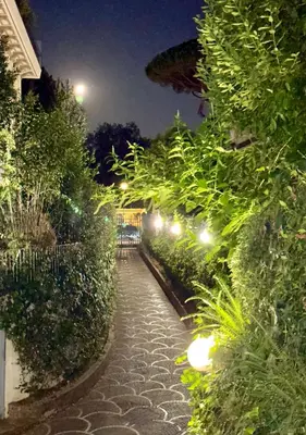 a walkway with plants and lights at night at Borghese Luxury Loft - LIBERTY COLLECTION in Rome