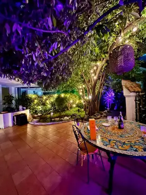 a patio with a table and chairs and purple lights at Borghese Luxury Loft - LIBERTY COLLECTION in Rome