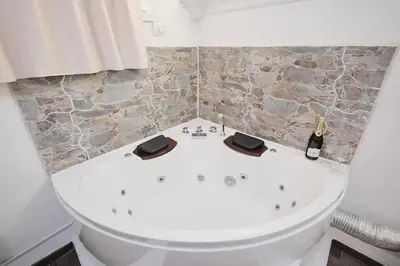 a bathroom with a bath tub with a bottle of champagne at Casa Chicca Monti - Idromassaggio 900 m Colosseo in Rome
