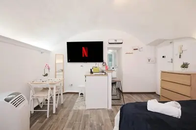 a room with a tv on the wall with a bed at Casa Chicca Monti - Idromassaggio 900 m Colosseo in Rome