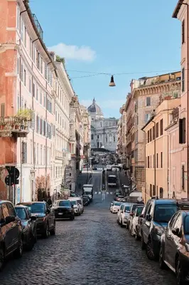 a city street with cars parked on a cobblestone road at Casa Chicca Monti - Idromassaggio 900 m Colosseo in Rome