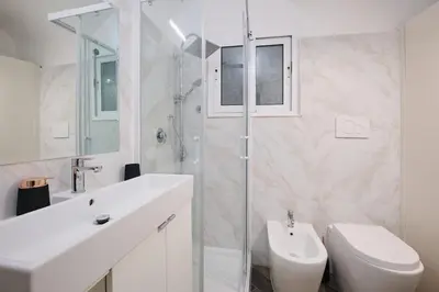 a white bathroom with a sink and a toilet at Casa Chicca Monti - Idromassaggio 900 m Colosseo in Rome