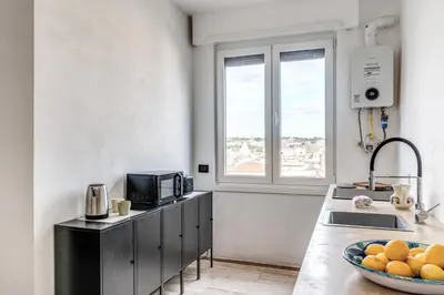 a kitchen with a counter with a microwave and a bowl of oranges at Amazing Piramide Metro Station in Rome